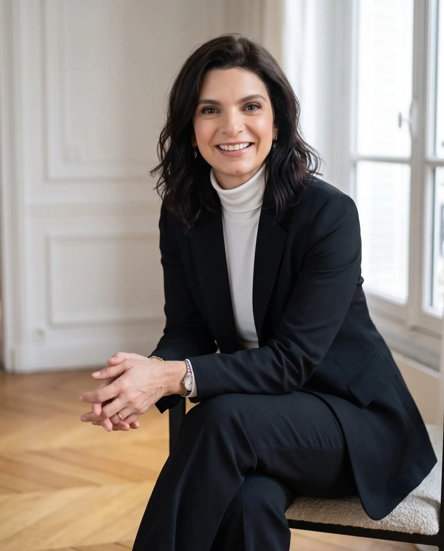 Emilie Valencia seated in a bright Parisian interior